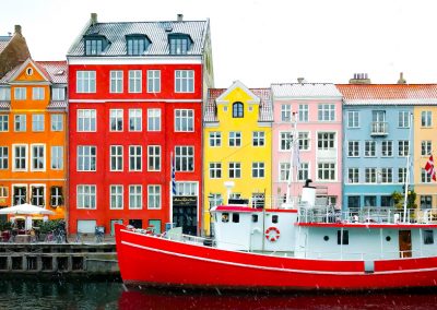 Red boat in front of colorful building in Copenhagen, Denmark