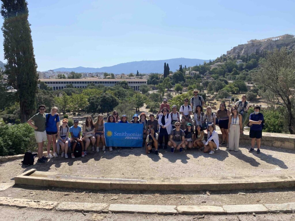 Group of students holding blue Smithsonian Journeys flag.