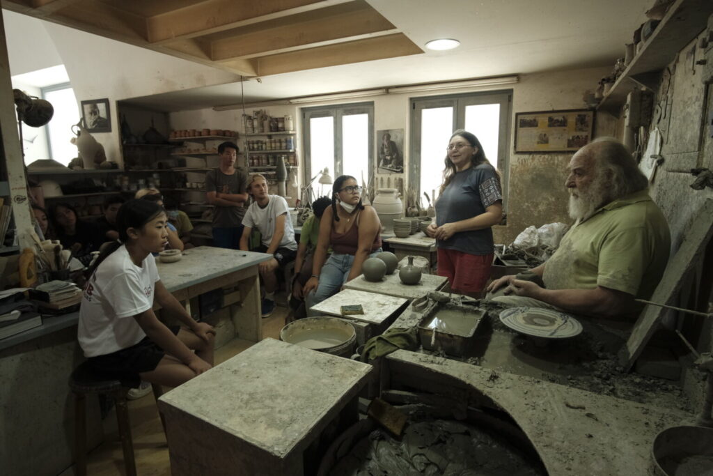 Group of students and leaders in pottery studio. 