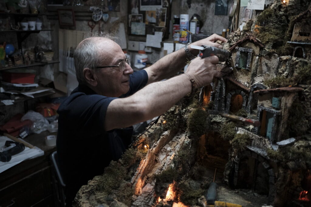 Man building diorama using natural materials.