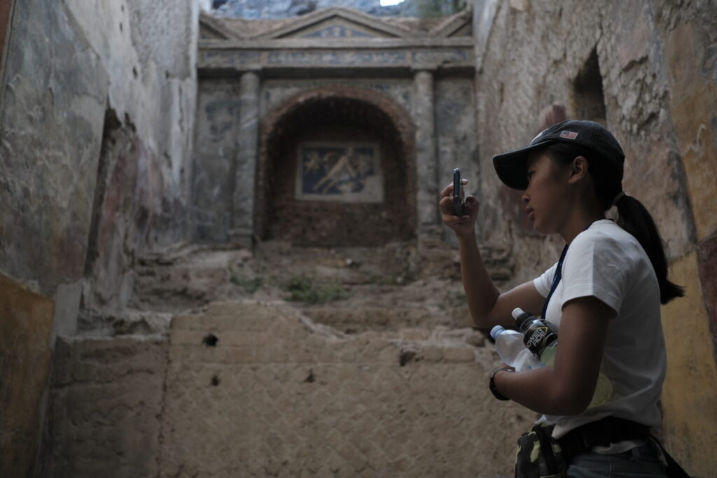 Student taking photo of baths in Pompeii.