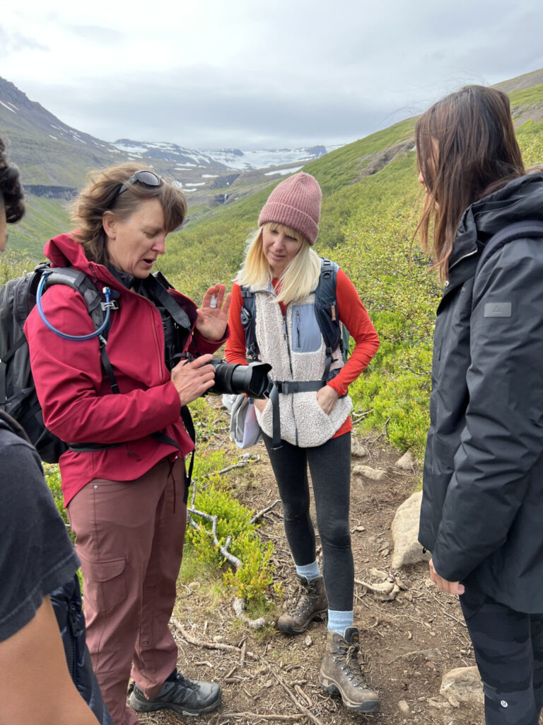 Students looking at guide holding camera.