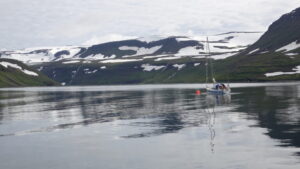 boat on the water in front of snowy hill