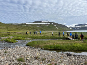 students hiking across green field