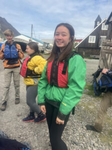 smiling student wearing red life vest