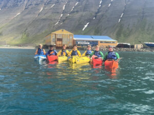 group of students in yellow and red kayaks in water