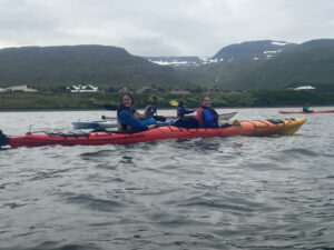 students kayaking in red kayak