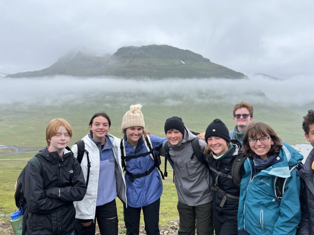 Group of students smiling in front of rolling fog.