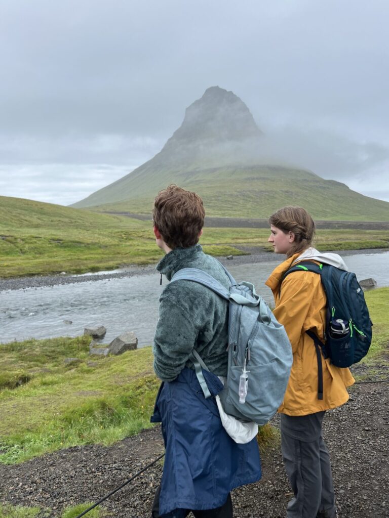 Two students looking into distant green field.