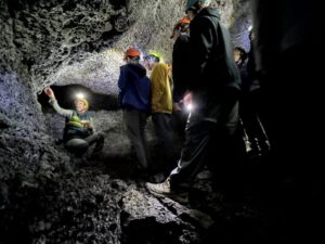 Students wearing hard hats in cave.