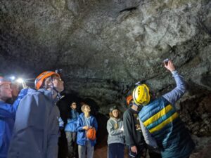 Students wearing hard hats in cave.