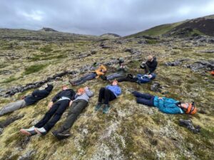 Students laying down on field.