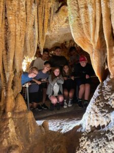 Students standing behind stalagmites and stalactites.