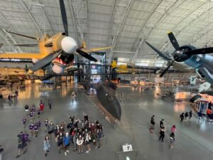 Aerial view of students next to planes.