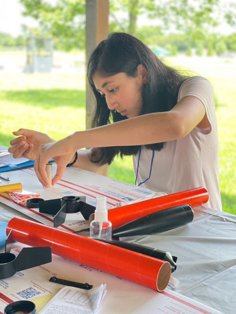 Close up of student focusing on building rocket.