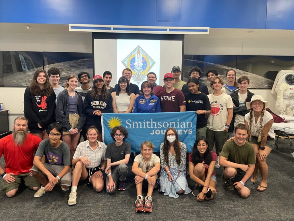 Group of students holding blue Smithsonian Journeys flag.